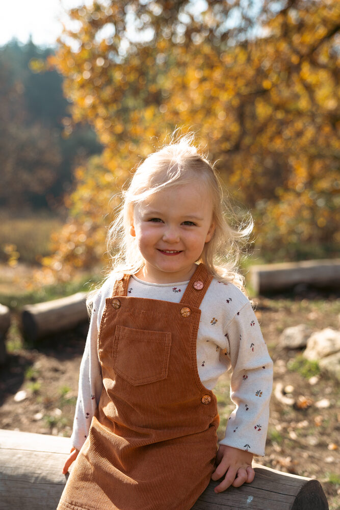Lachendes Kind im Wald in warmem Herbstlicht