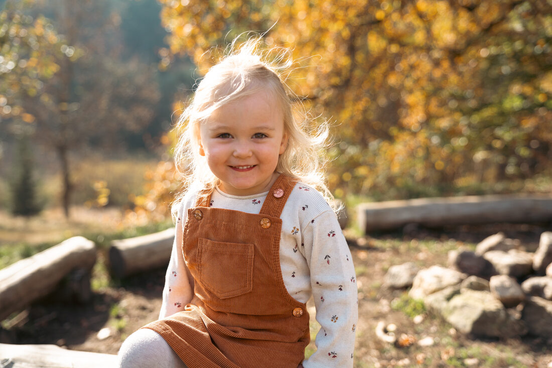 Kind lächelt fröhlich im Wald